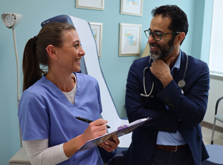 A doctor and a nurse are conversing in a medical examination room.
