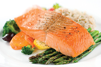 The image shows a plated meal featuring a grilled salmon fillet with asparagus, rice, and assorted vegetables.