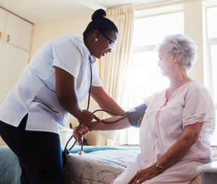 A nurse measuring the blood pressure of an elderly woman in a clinic.