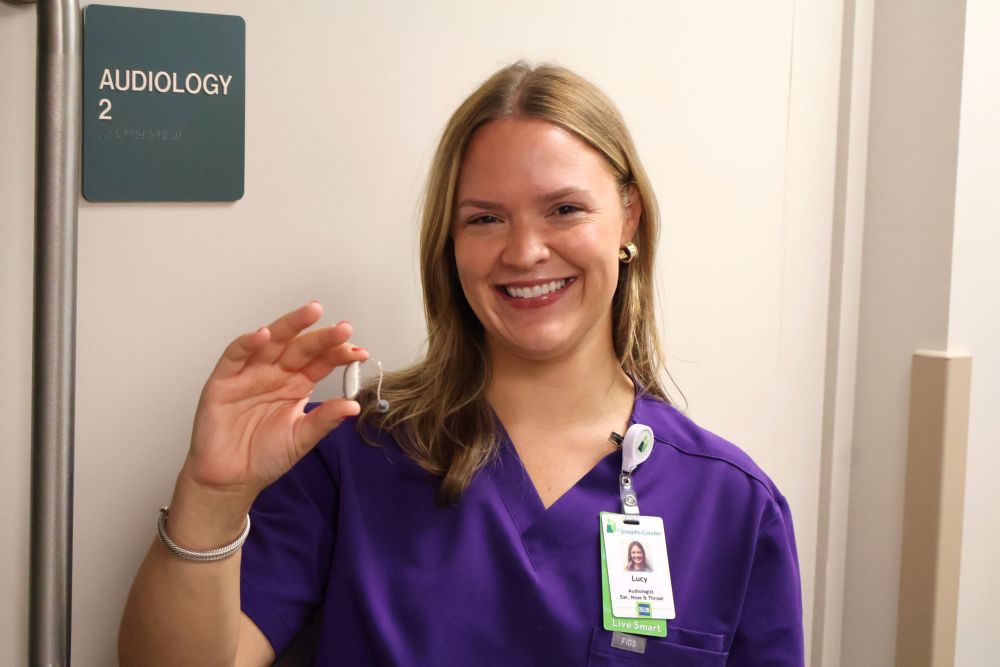 St. Joseph's/Candler Audiologist Lucy Bradshaw holding an example of a hearing aid