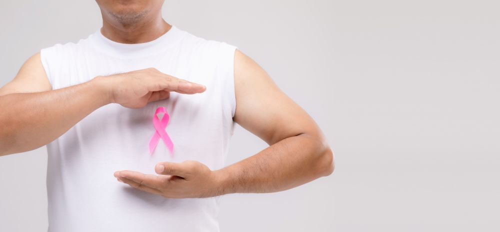 Man in white t-shirt with a pink ribbon to support breast cancer patients
