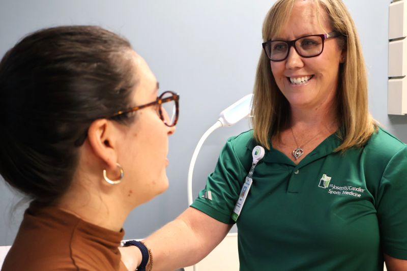 St. Joseph's/Candler athletic trainer examines a patient's shoulder