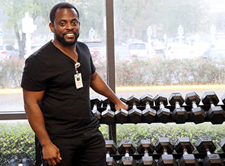A smiling man with dumbbells.
