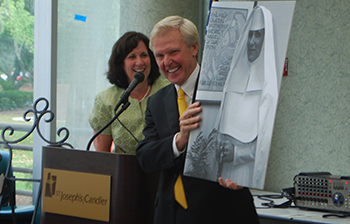 SJ/C President & CEO Paul P. Hinchey shows a photo of McAuley Award winner Debbie Shumans dressed up as a Sister of Mercy