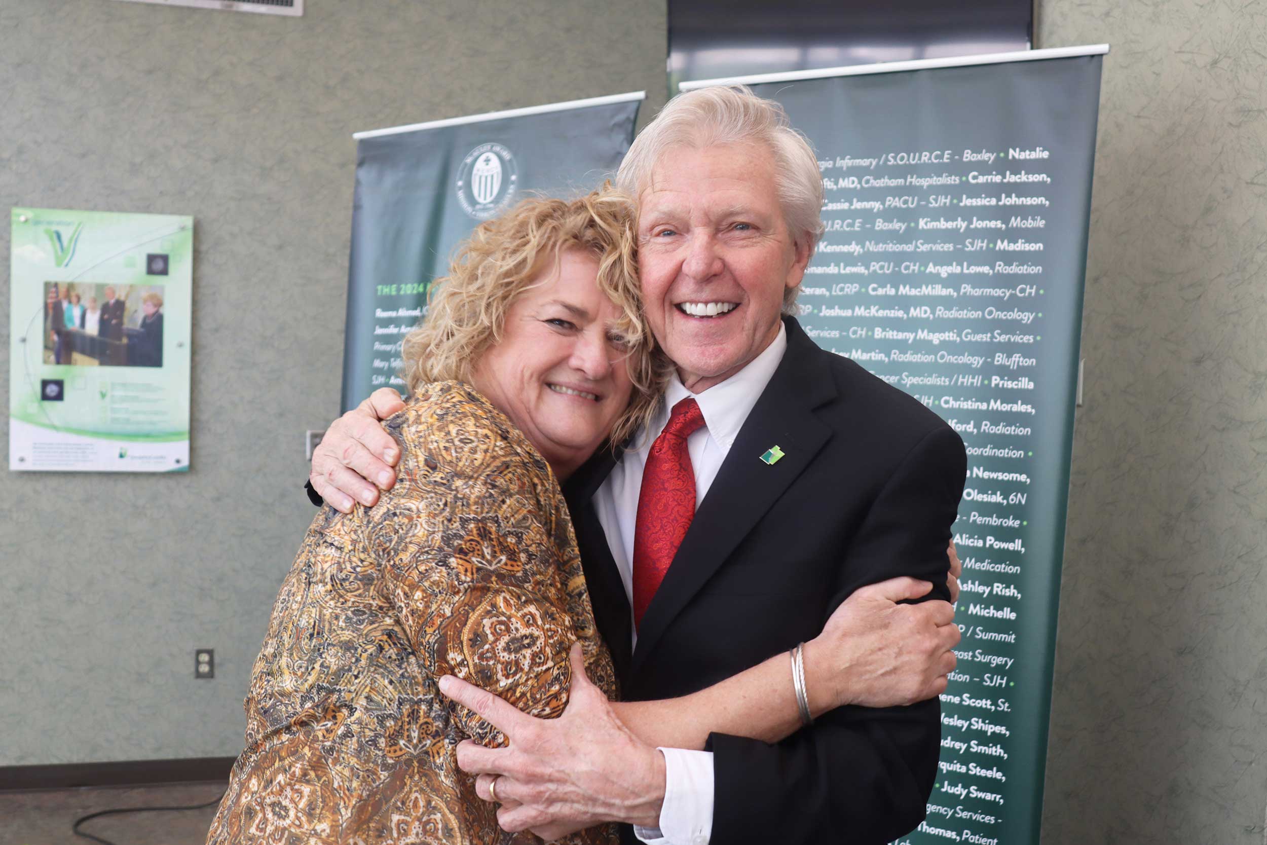 Sherri Clark receiving a congratulatory hug from Paul P. Hinchey.